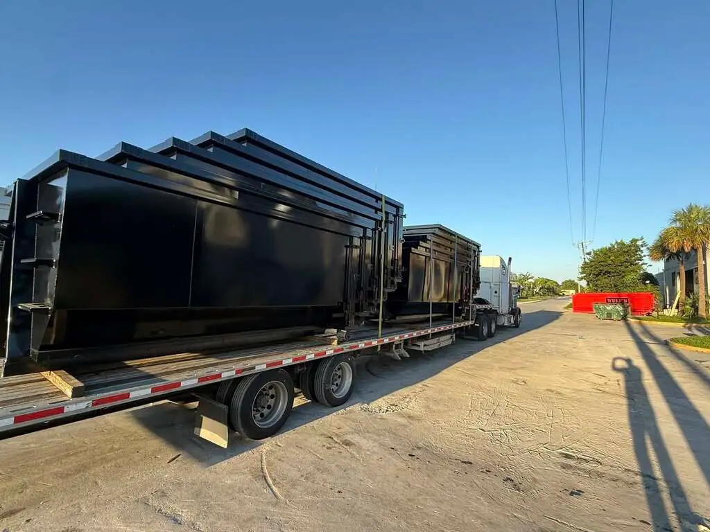 Gallery 10 Multiple roll-off dumpsters loaded on trailer for commercial dumpster rental service in Saginaw MI