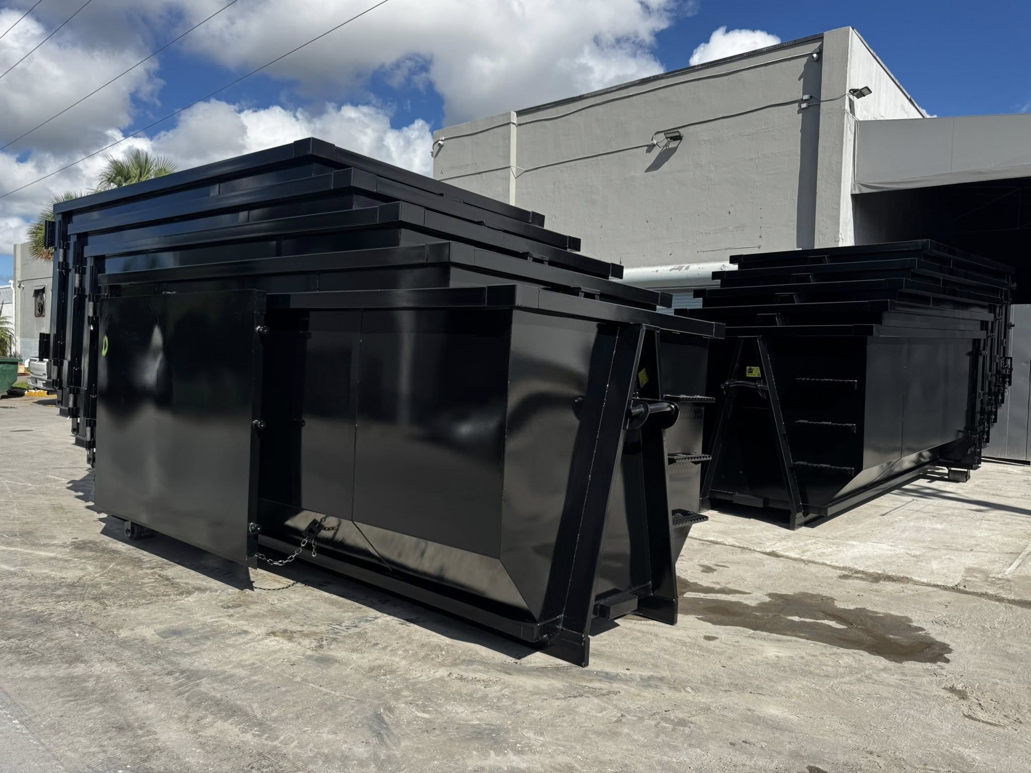 New black roll-off dumpsters stacked at facility and ready for residential and commercial dumpster rental service in Saginaw Michigan