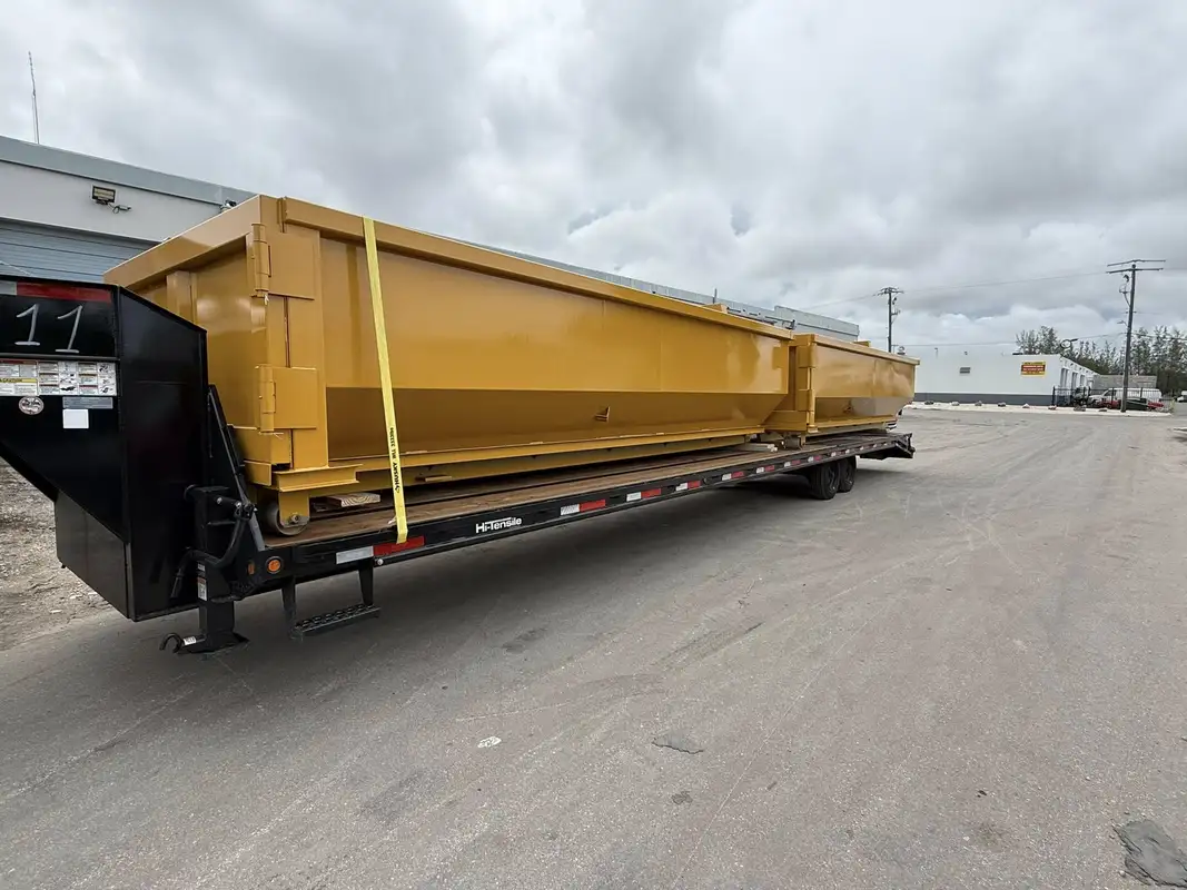 Gallery 12 Large yellow roll-off dumpster secured on flatbed trailer for construction dumpster rental service in Saginaw Michigan
