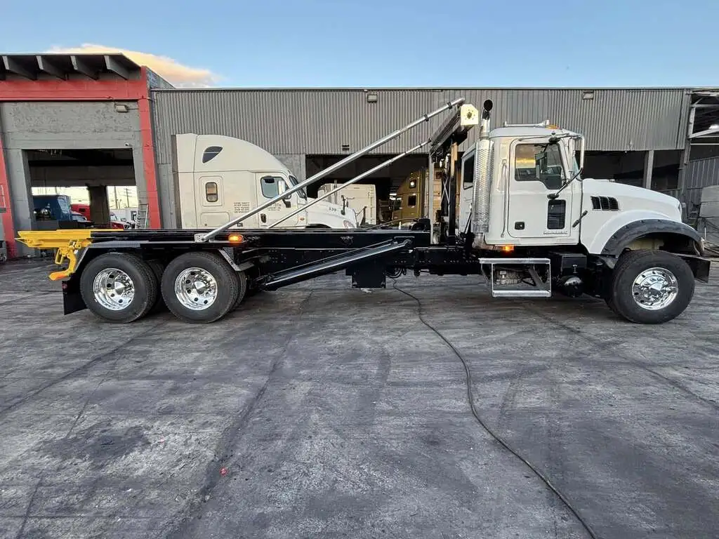 Gallery 8 White roll-off dumpster truck parked at service facility for residential and commercial dumpster rentals in Saginaw MI