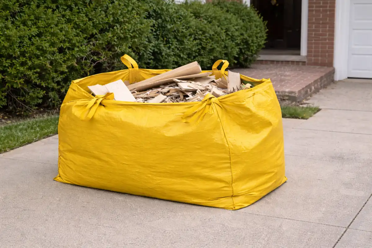 Yellow dumpster bag filled with construction debris on a residential driveway